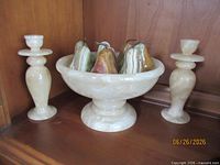 Bowl filled with pears between two candlesticks