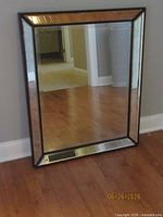 Full view of rectangular decorative mirror leaning against wall
