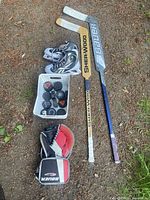 Full lot showing sticks, skates, pucks basket, blocker