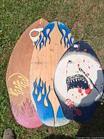 Front view of three skimboards showing graphics and sizes