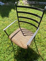 Front three-quarter view of one wrought iron patio chair showing overall design and condition