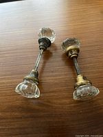 Two complete crystal door knob sets on wood surface