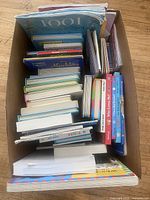 Top view of box filled with children’s books showing variety of titles and formats