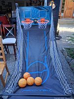 Full view of arcade basketball game setup with balls