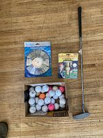 All items overview: putter, boxed golf balls, aluminum putting cup in package, Eject-A-Putt in package
