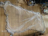 Full view of the white nylon net with black edging spread on floor