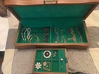 Open jewelry box showing overall contents in main compartment and removable tray