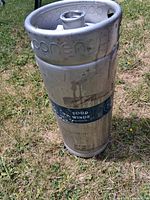 Full view of stainless steel keg showing label and overall condition