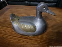 Side view of cast metal duck container