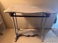 Full view of table front showing spindle legs, missing drawer, stretcher, paint wear