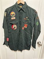 Full front view of dark green BSA Explorer shirt showing patches and pins