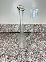 Full view of clear glass bud vase on countertop