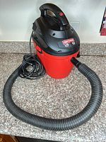 Front view of Craftsman wet/dry vacuum with hose attached