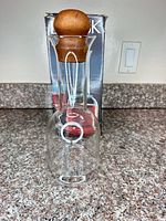Front view of glass carafe with wood stopper and box behind