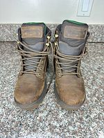 Front view of both boots showing leather uppers, laces, tongue branding