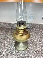 Full view of Favor brass and tin oil lamp with glass chimney