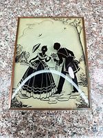 Front view of reverse-painted glass artwork in metal frame
