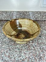 Top ¾ view of brown speckled stoneware bowl on countertop