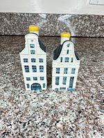 Front view of both KLM Delft Blue miniature house bottles with yellow caps