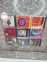 9 CDs laid out on countertop, overall view