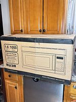 Factory box showing microwave outline and key specs