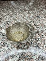 Top view of ornate silver-plated bowl showing gold-tone center and detailed embossing