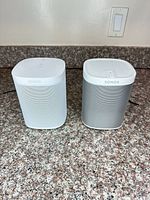 Two Sonos speakers side by side on counter