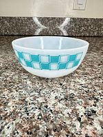 Side view showing turquoise checked band and milk glass body