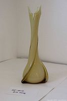 Full view of light yellow 3-prong swung vase showing twisted design and flared rim