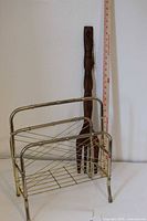 Full view of teak fork beside metal record rack, tape measure shows fork height