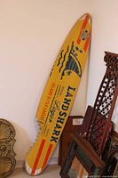 Front of wood surfboard sign with LandShark Lager graphics