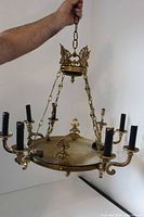 Full view of brass chandelier showing eight arms and chain