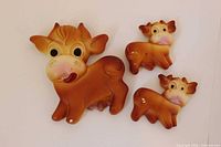Front view of three chalkware cow wall hangings