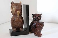 Front view of wood owl bookend and two ceramic owls