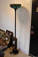 Full view of floor lamp showing glass shade, column, base