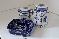 Two blue floral clamp-lid canisters and blue floral dish grouped together