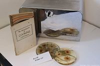 Front view of chrome bread box with cookbook set and two lucite plaques