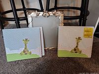 Front view of two baby giraffe albums and one silver-frame wedding album