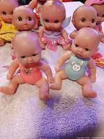 Front view showing eight baby dolls in assorted outfits