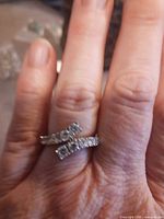 ring worn on hand showing crossover rhinestone design