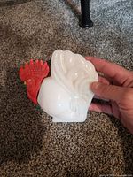 Front view of rooster bottle showing white body and red head