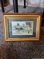 Front view of framed print with gold frame and green mat