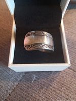 Ring front view in box showing engraved pattern