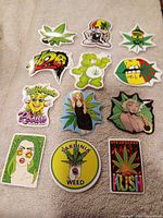 Group of weed-themed vinyl stickers laid out on fabric
