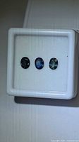 Front view of three oval sapphires in display box