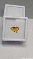 Front view of yellow-orange triangular sapphire in display box