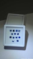 Front view of 13 square blue sapphires in display case