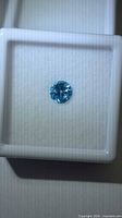 Top view of single blue zircon in display case