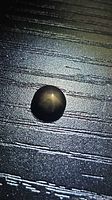 Top view of round black star sapphire showing star effect