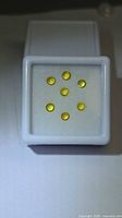 Front view of seven lemon yellow sapphire round cabochons in display box
